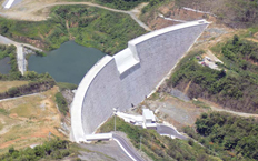 Aerial view of the hydroelectric dam evacuating water surrounded by hydroelectric posts in charge of transporting the energy