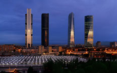 Frontal view of the four towers of Madrid at dusk.