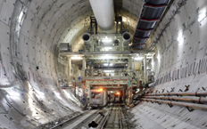 View of the interior of the tunnel during the construction phase, with the tunnel boring machine in the background